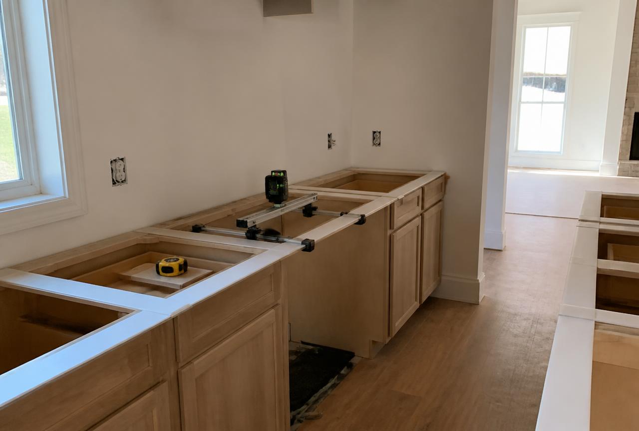 Countertop templating in progress over newly installed kitchen base cabinets before stone fabrication